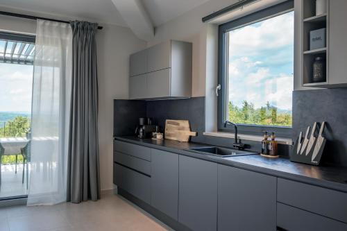 a kitchen with a sink and a large window at Villa TonKa with jacuzzi sauna and private pool in Labin