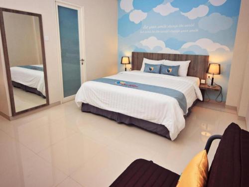 a bedroom with a large bed and a mirror at Graha Cempaka Boutique Hotel in Surabaya