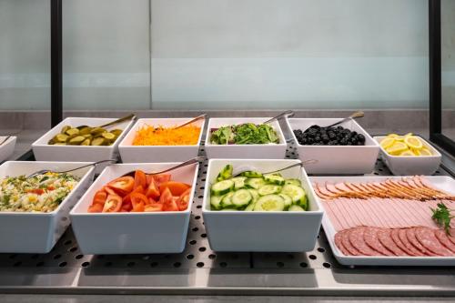 a buffet with different types of vegetables in trays at Art City Inn in Vilnius