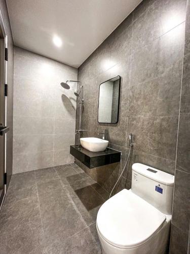 a bathroom with a toilet and a sink and a mirror at Vina Apartment- Căn hộ trung tâm Huế in Thôn Trường Giang