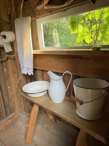 a pot and a pitcher on a table in a cabin at Charming Garden House by the River in Vanaküla
