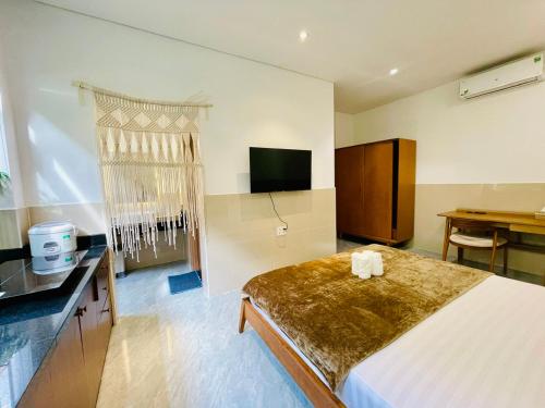 a bedroom with a large bed and a television at Tropical Mango House in Da Nang