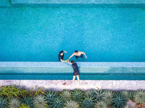 three men are standing in front of a swimming pool at Payana Kampot in Kampot