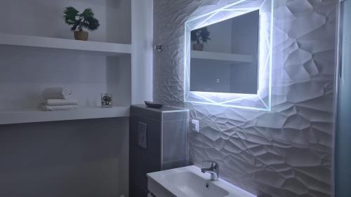a white bathroom with a sink and a window at SeaView Peramos 2 in Néa Péramos