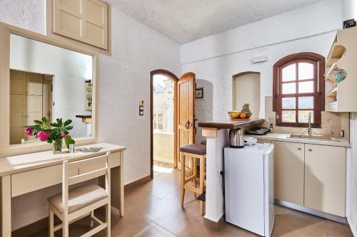 a kitchen with white cabinets and a counter top at Mila Malia Studios Hotel in Malia