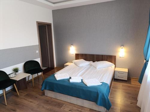 a hotel room with a bed and two chairs at Vila President Sovata in Sovata