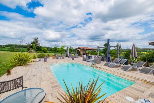 une piscine avec des chaises longues et une terrasse dans l'établissement La Villa a Bel-Endroit, à Marciac