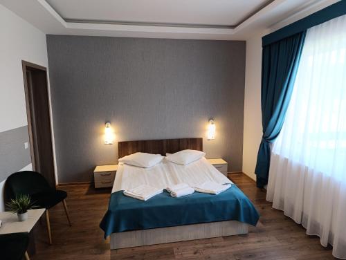 a bedroom with a bed with two pillows and a window at Vila President Sovata in Sovata