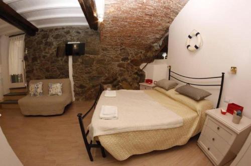 ein Schlafzimmer mit einem Bett und einer Steinwand in der Unterkunft Rio Alba red loft - holiday house - Riomaggiore 5terre in Riomaggiore