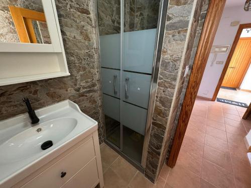 ein Badezimmer mit Waschbecken und Glasdusche in der Unterkunft Puerta del Mar in Calpe