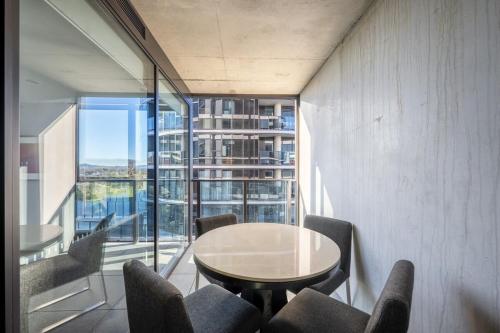a dining room with a table and chairs and a window at Self-Contained Apartment in Woden By Serain in Phillip