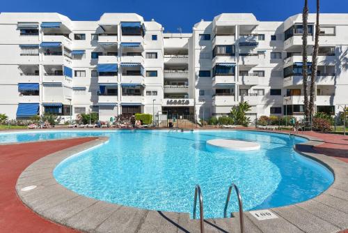 a large swimming pool in front of a building at Modern Iguazu Apartment in Playa del Ingles