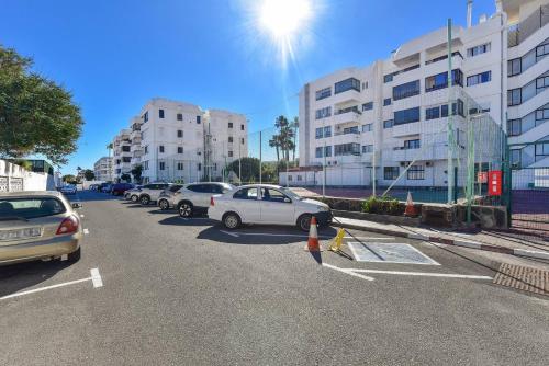a row of cars parked in a parking lot at Modern Iguazu Apartment in Playa del Ingles