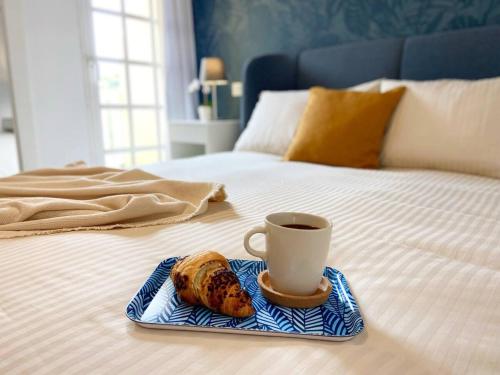 filiżanka kawy i muffinka na łóżku w obiekcie Apartament Tisalaya 44 By Pride Holiday Rentals w mieście Maspalomas