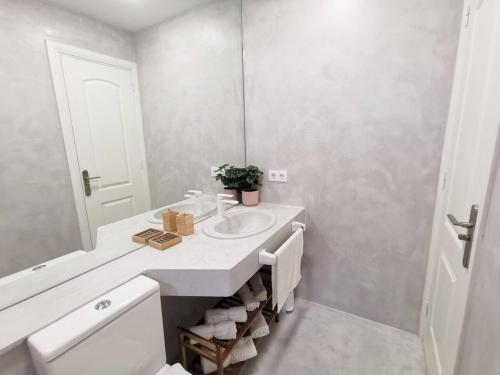 biała łazienka z umywalką i lustrem w obiekcie Apartament Tisalaya 44 By Pride Holiday Rentals w mieście Maspalomas