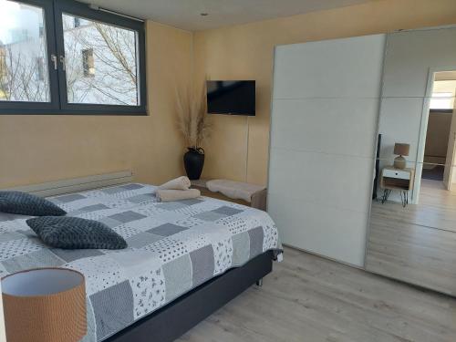 a bedroom with a large bed and a tv at Tolle Penthouse Wohnung direkt am Park in Heilbronn