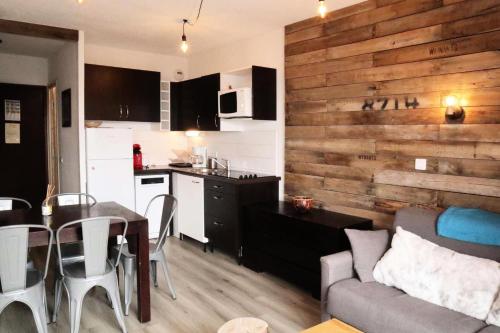 Il comprend une cuisine et un salon avec un mur en bois. dans l'établissement Residence La Combe D Or - Appartement en résidence de standing MAE-0814, aux Orres