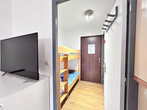 une chambre avec une télévision et un couloir avec un lit superposé dans l'établissement Soleil- 4 pers Hyper centre Plage - 2 min - Terrasse, à Saint-Raphaël