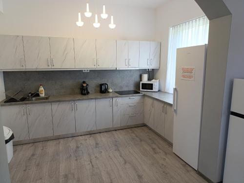 a kitchen with white cabinets and a white refrigerator at Vila President Sovata in Sovata