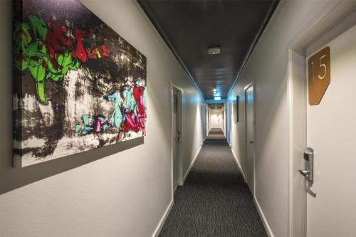 a corridor of a hallway with paintings on the walls at Nightcap at Chester Hill Hotel in Bankstown