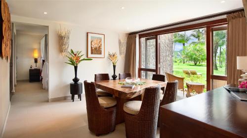 a dining room with a wooden table and chairs at Kempinski Seychelles Resort in Baie Lazare Mahé