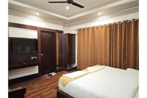 a bedroom with a bed and a flat screen tv at Greater Ladakh Residency in Leh