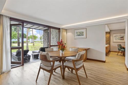 a dining room and living room with a table and chairs at Kempinski Seychelles Resort in Baie Lazare Mahé