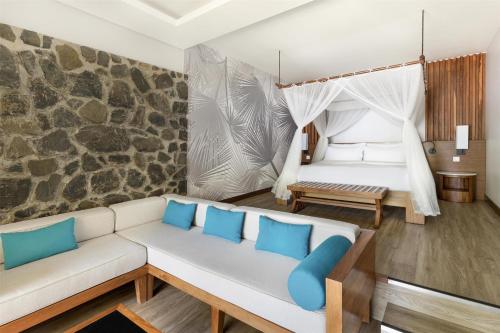 a living room with a couch and a bed at Kempinski Seychelles Resort in Baie Lazare Mahé