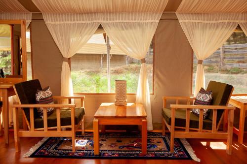 une chambre avec deux chaises, une table et une fenêtre dans l'établissement Gangtey Tent Resort, à Gangtey Gonpa