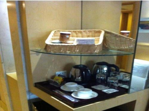 a shelf with a tea kettle and a basket on it at Ramada Plaza Shenyang Citycenter in Shenyang