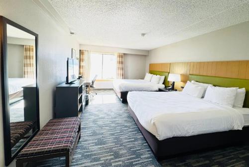 a hotel room with two beds and a television at Wingate by Wyndham Lincoln Airport East I-80 in Lincoln
