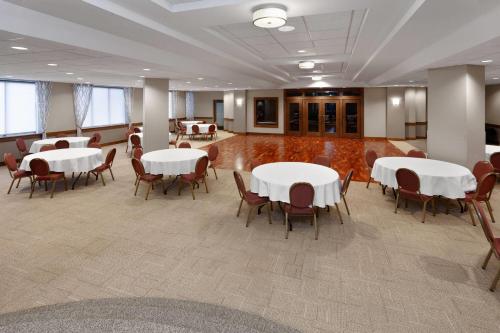 a meeting room with tables and chairs in a building at Ramada by Wyndham Milwaukee in Milwaukee
