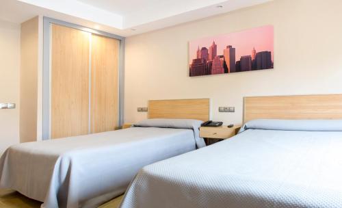 a hotel room with two beds and a city at Hotel Olympia Ronda I in El Puig