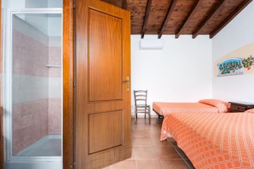 a door leading to a bedroom with a bed and a tub at Su Birde Agriturismo in Orosei