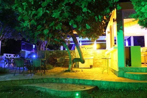 a table and chairs under a tree at night at Sea Sun in Plomarion