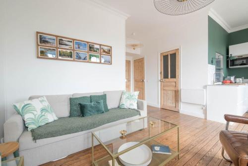 un salon avec un canapé et une table en verre dans l'établissement Bel appartement Pornichet, à Pornichet