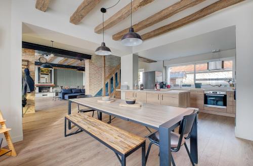 une salle à manger et une cuisine avec une table et des bancs dans l'établissement Maison des Sources Touraine, à Esvres