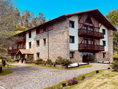 Un gran edificio de piedra con balcones. en Hotel-Apartamento Rural Atxurra, en Bermeo