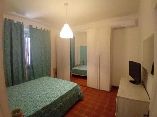 una camera da letto con un letto e una televisione di Casa Lividonia a Porto Santo Stefano