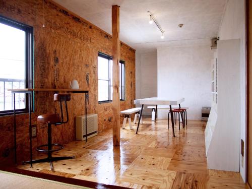 a living room with a table and chairs in it at Kamifu INN in Kami-furano