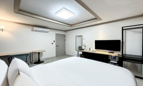 a hotel room with a bed and a flat screen tv at Gumi time hotel in Gumi