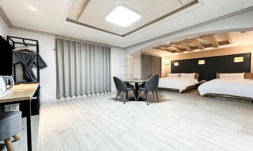 a hotel room with two beds and a table and chairs at Gumi time hotel in Gumi