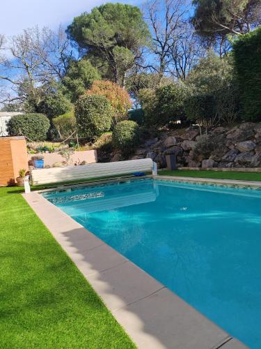 - une piscine avec un banc à côté d'une cour dans l'établissement Villa privée, piscine chauffée, jacuzzi et sauna, à Saint-André-dʼOlérargues