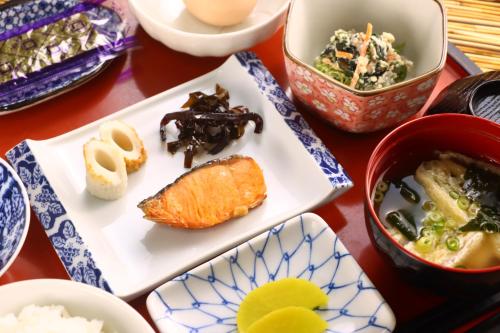 a table with plates of food and bowls of food at Kenrokuen in Nobeoka