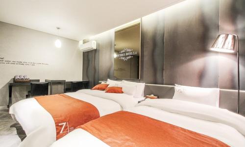 two beds sitting next to each other in a room at Jamsil 2.4 Hotel in Seoul