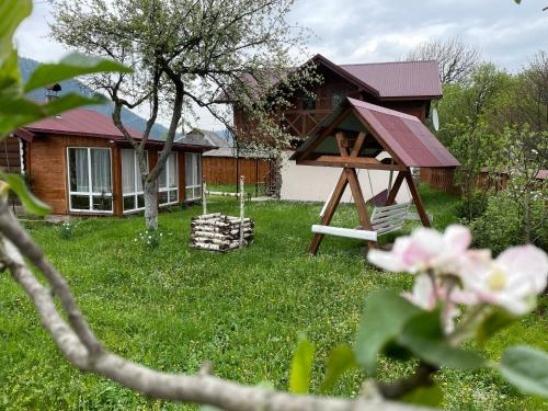 a yard with a house and a playground at Pidkova in Verkhovyna