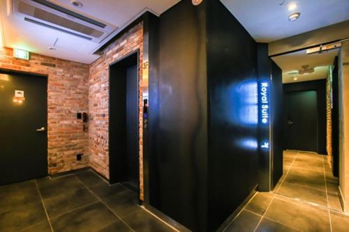 a hallway with two doors and a brick wall at Jamsil 2.4 Hotel in Seoul