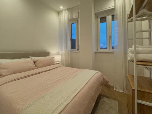 a bedroom with a bed and two windows at Roccia Verde apartment in Cernobbio