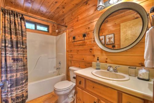 ein Bad mit einem WC, einem Waschbecken und einem Spiegel in der Unterkunft Bearfoot Ridge Wood-burning fireplace cozy hot tub serene views in Ellijay