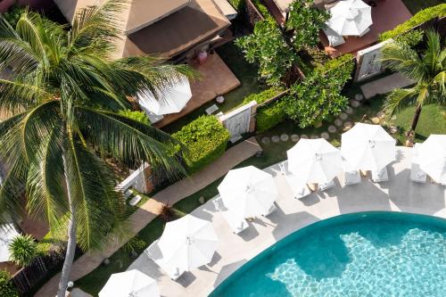 an overhead view of a pool with chairs and umbrellas at Khwan Beach Resort - Luxury Glamping and Pool Villas Samui - Adults Only - SHA Extra Plus in Mae Nam